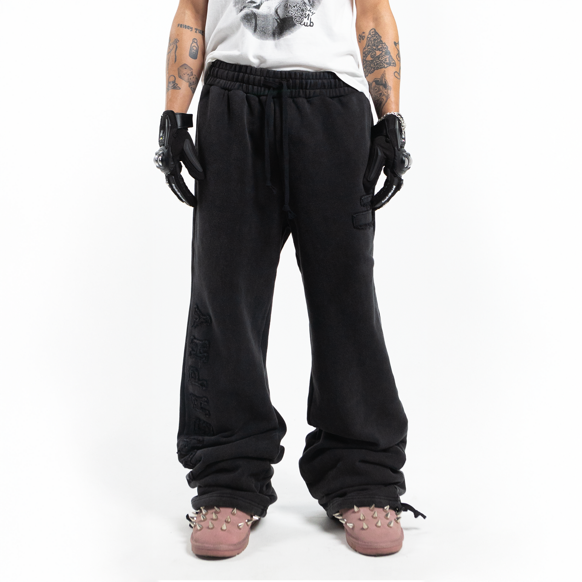 Nikolas Crow wearing Prngrphy - Wide Leg Varsity Trousers - Front - Studded Suede Boots in pink
